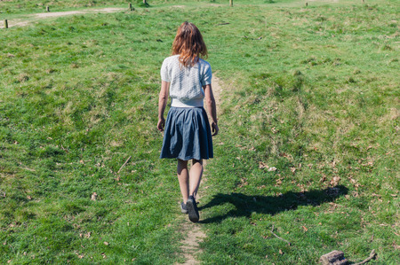 A young woman is walking in the countrysideの写真素材