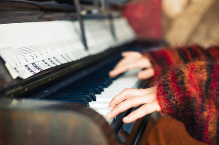 The hands of a young woman as she is playing the pianoの写真素材