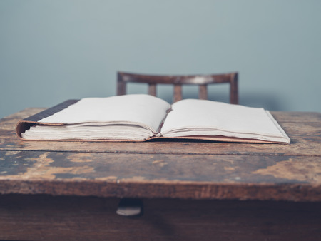 An open notebook on an old wooden deskの写真素材