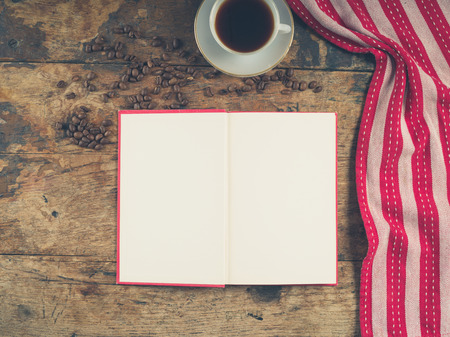 Overhead shot of coffee concept with empty cup, tea towel and an open book with blank pagesの写真素材