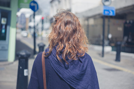 A young woman is walking in the street