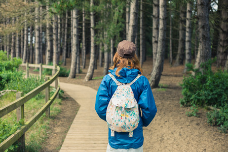 A young woman is walking alone in the forestの写真素材