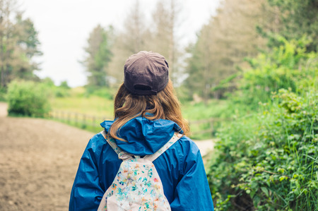 A young woman is walking alone in the forestの写真素材