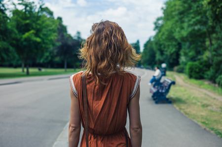 A young woman is walking in a parkの写真素材