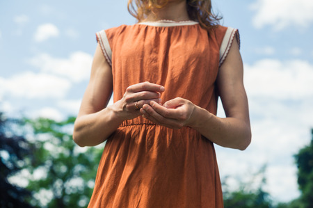 A young woman is standing outside in natureの写真素材