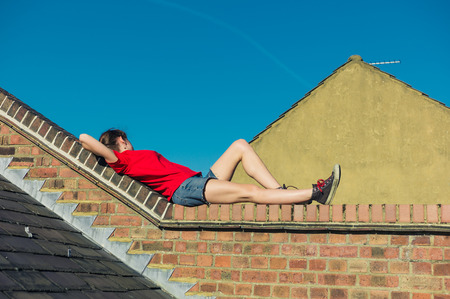 A young woman is lying on a rooftop and is relaxingの写真素材