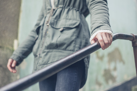 The hand of a woman holding on to a metal banister outsideの写真素材