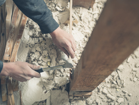 The hands of a young person using a hammer in a pile of rubbleの写真素材