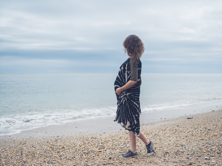 A young pregnant woman is walking on the beachの写真素材