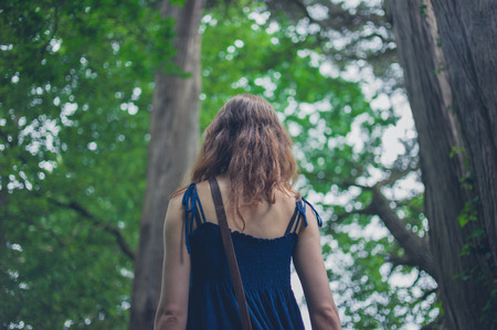 A young woman is standing in a forestの写真素材