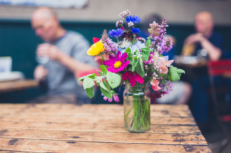 A bouquet of wild flowers on a table in a cafeの写真素材
