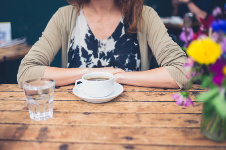 A young woman is having a cup of coffee in a cafeの写真素材