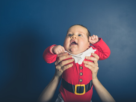 A happy little baby wearing a santa costumeの写真素材