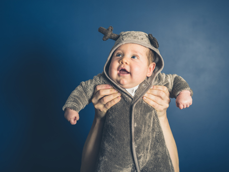 A happy little baby wearing a reindeer costumeの写真素材