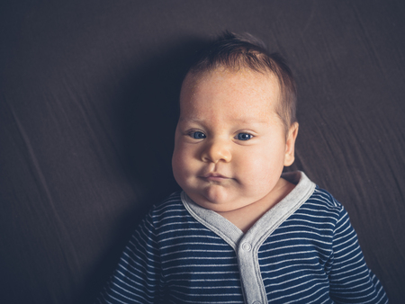 A cute little baby on a bedの写真素材