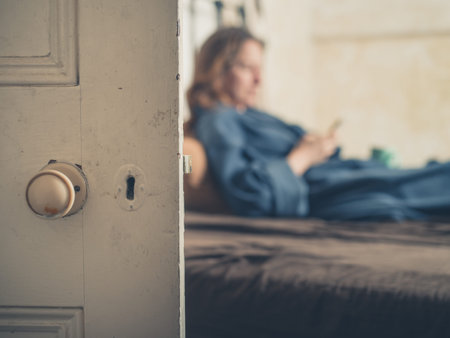 Close up on a door with a woman on a bed in the background
