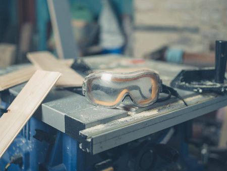 Safety goggles on a table saw with wood