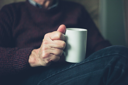 A senior man is relaxing at home with a mug of teaの写真素材