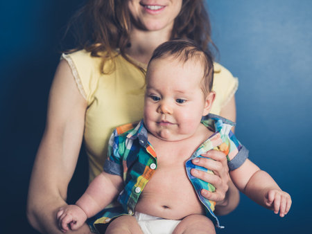 A young mother with a happy baby in a summer shirt