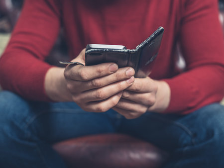 Close up on a man sitting on a sofa using a smartphone