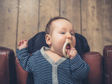 A little baby is chewing on a teething ringの写真素材