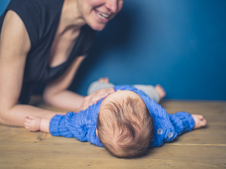 A young mother with a little baby in blueの写真素材