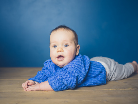 A happy little baby is exploring and learning to crawlの写真素材