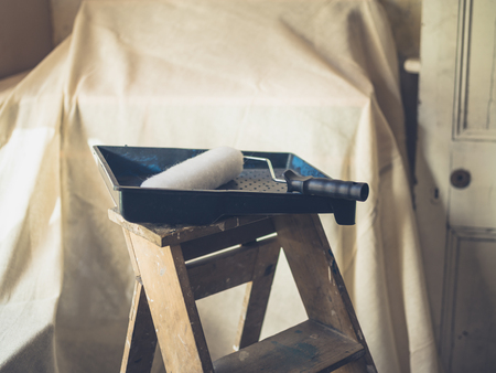A paint roller and tray on a stepladderの写真素材