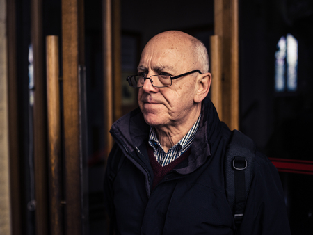 A senior man is standing in a churchの写真素材