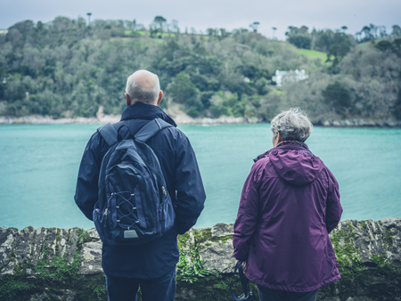A senior couple is admiring the view of a river in springの写真素材