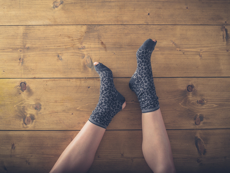 Overhead shot of a woman's feet in worn socks on the floorの写真素材