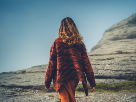 A young woman is walking in the fog on a moorの写真素材