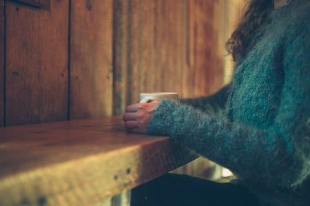A young woman is drinking coffee in a cafeの写真素材