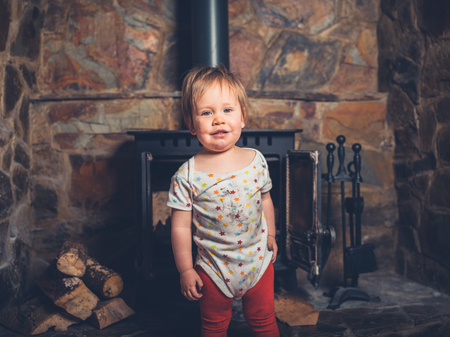 A happy little boy is covered in sud and dirt from playing with a log burnerの写真素材