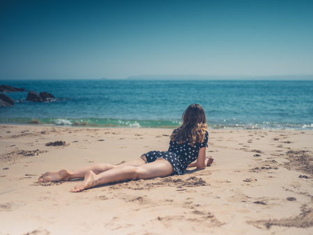 A beautiful young woman is relaxing on the beachの写真素材