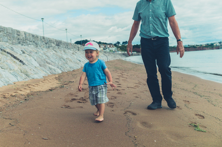 A grandfather and grandchild on the beachの写真素材