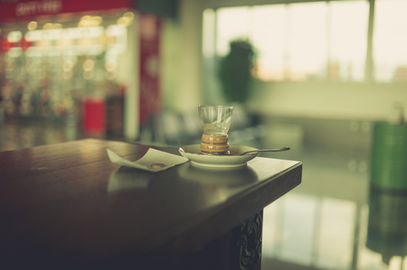 An empty cup of coffee at the airport with a receipt and a coinの写真素材