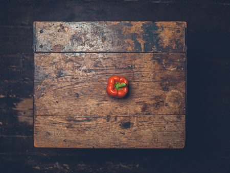 Overhead shot of a red pepper on a wooden tableの写真素材