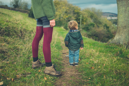 A young mother and her toddler are walking in the countrysideの写真素材