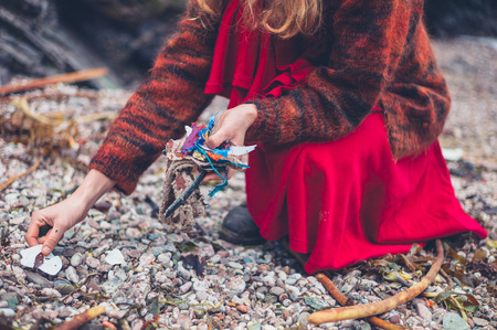 A young woman is cleaning up plastic rubbish on the beachの写真素材