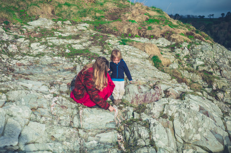 A mother and her toddler are relaxing on rocks in natureの写真素材