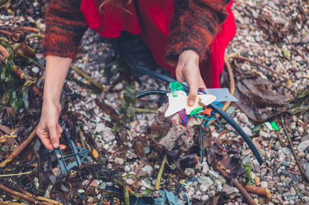 A young woman is cleaning up plastic rubbish on the beachの写真素材