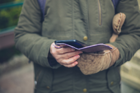 A senior woman is using her smartphone outdoors in the winterの写真素材