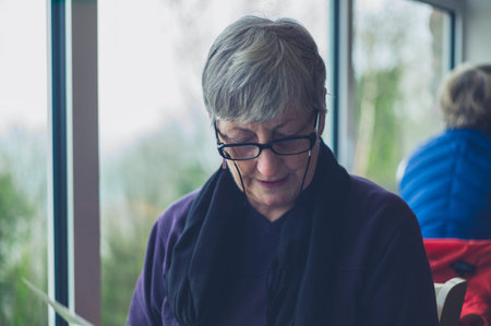 A senior woman is looking at the menu in a cafe