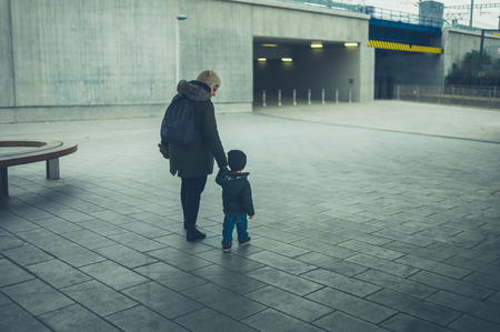 A little toddler and his grandmother are walking in the cityの写真素材