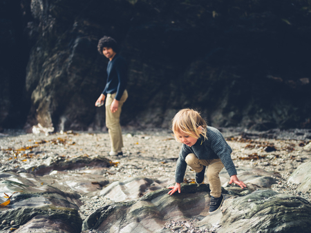 A little toddler is on the beach with his fatherの写真素材