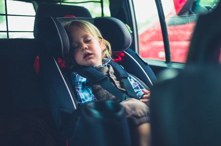 A little toddler is sleeping in the car seatの写真素材