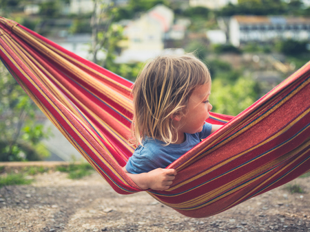 A little toddler is relaxing in a hammockの写真素材