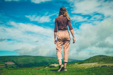 A young woman is walking in the wilderness on a sunny summer dayの写真素材