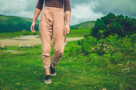 A young woman is walking in nature on a sunny summer dayの写真素材